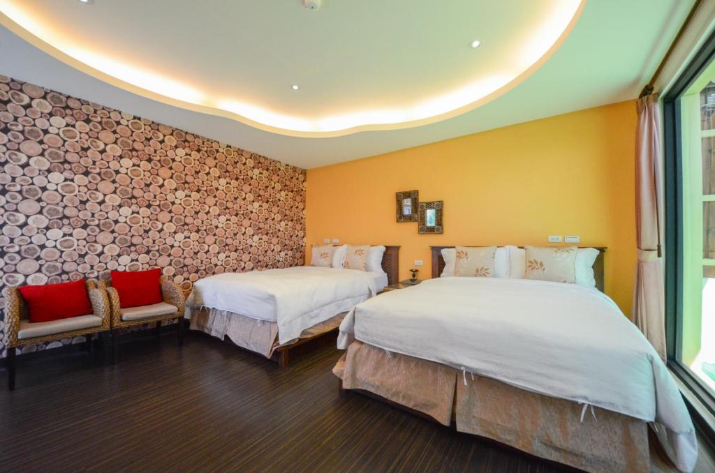 two beds in a room with yellow walls at Ciao House B&B in Kenting