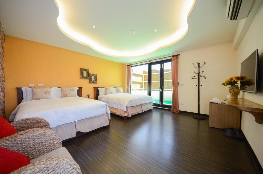 a hotel room with two beds and a tv at Ciao House B&B in Kenting