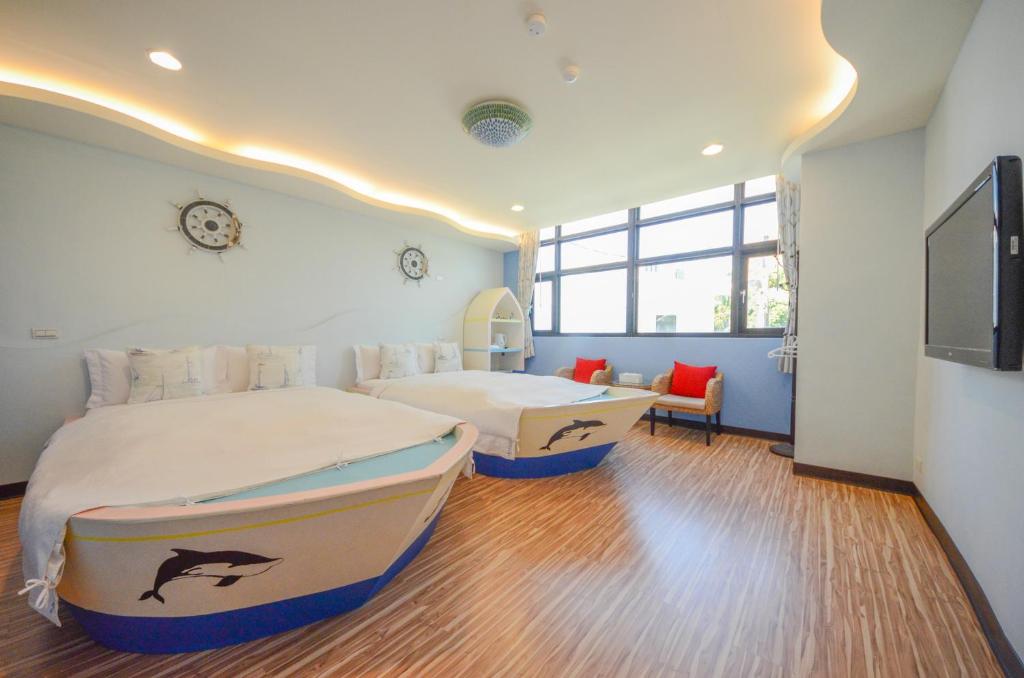 a bedroom with two beds and a flat screen tv at Ciao House B&B in Kenting