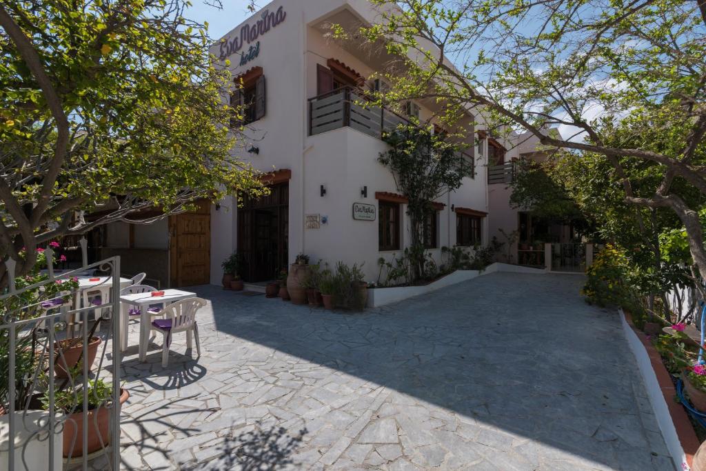 a building with a patio in front of it at Hotel Eva Marina in Matala