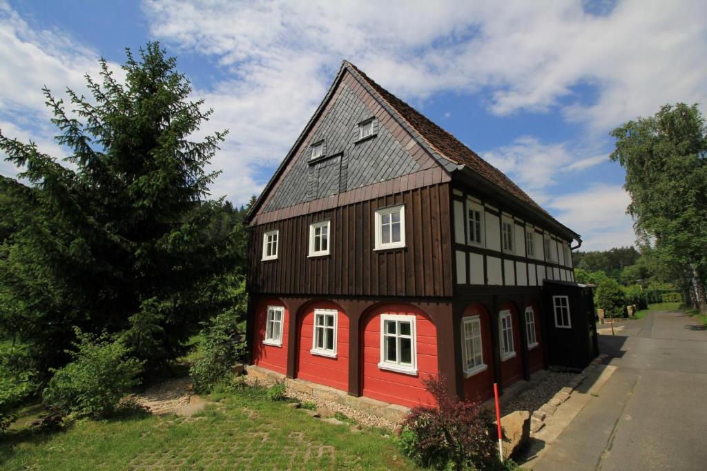 ein braunes und rotes Haus mit einer roten Tür in der Unterkunft Oberlausitzer Ferienhaus Gebirgshäusl Jonsdorf in Kurort Jonsdorf