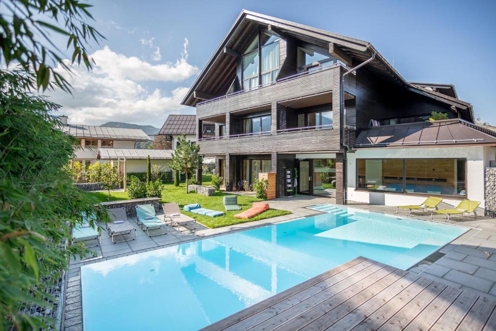 an exterior view of a house with a swimming pool at Das Freiberg Romantikhotel in Oberstdorf