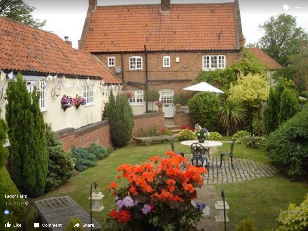 une maison avec un jardin fleuri dans la cour dans l'établissement Tudor Farm B&B, à Elston