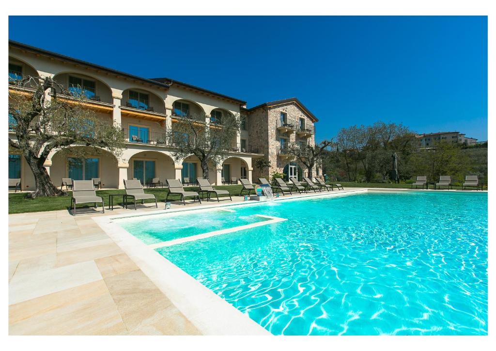 uma grande piscina em frente a um edifício em Ca' Barbini Resort em Garda
