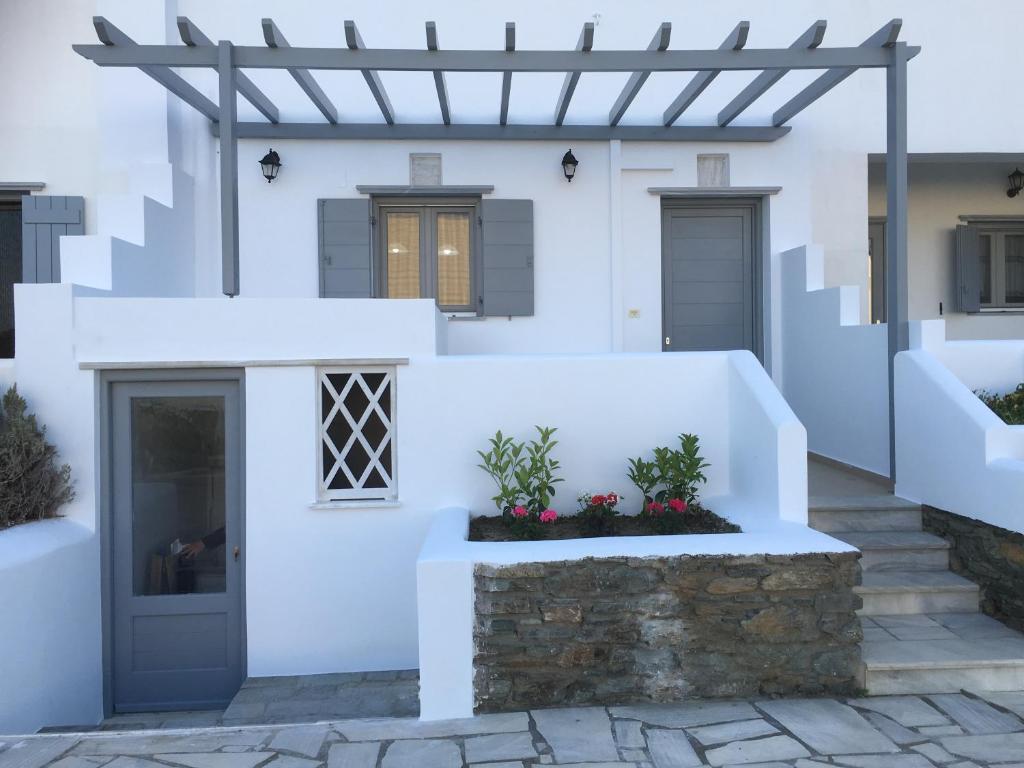 a white house with stairs and a door at Boussetil Apartment in Tinos