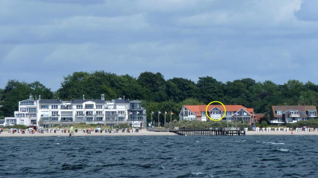 duży budynek na plaży z dużym żółtym pierścieniem w obiekcie Penthouse Ostseepanorama w mieście Pelzerhaken