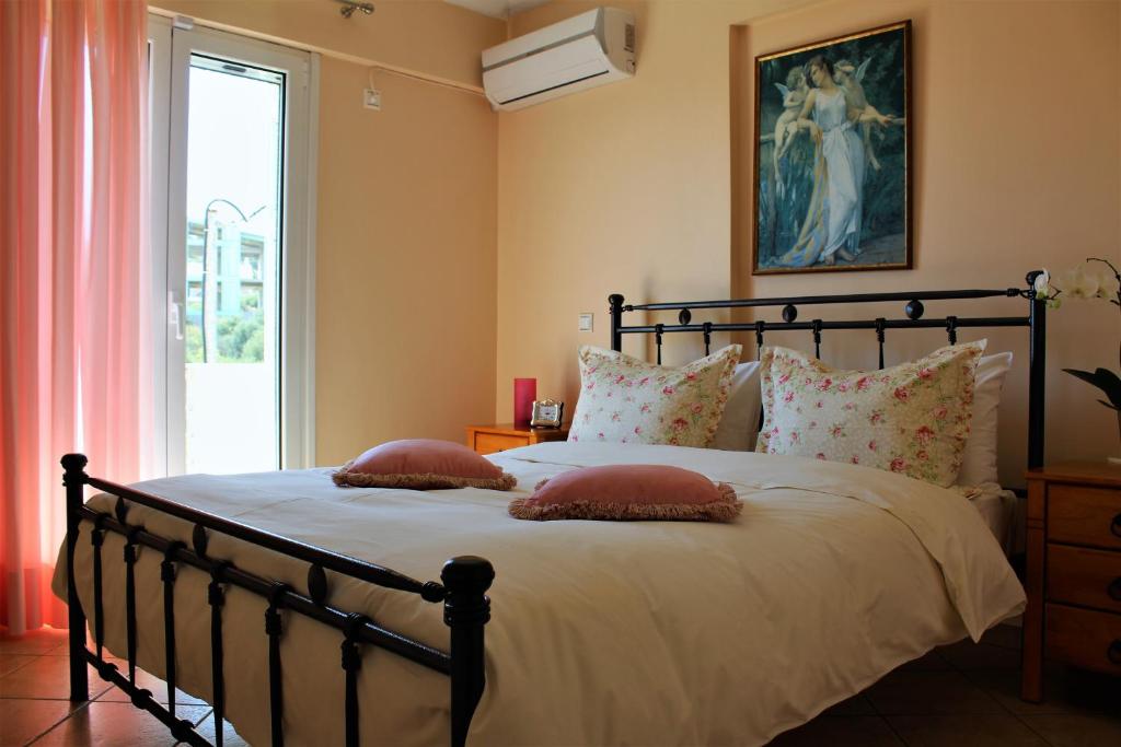 a bedroom with a large bed with pillows and a window at Helen's Sounio Apartments in Sounio