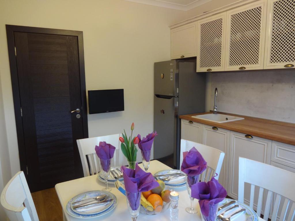 a kitchen with a table with purple flowers on it at Apartments Dona in Chernomorets