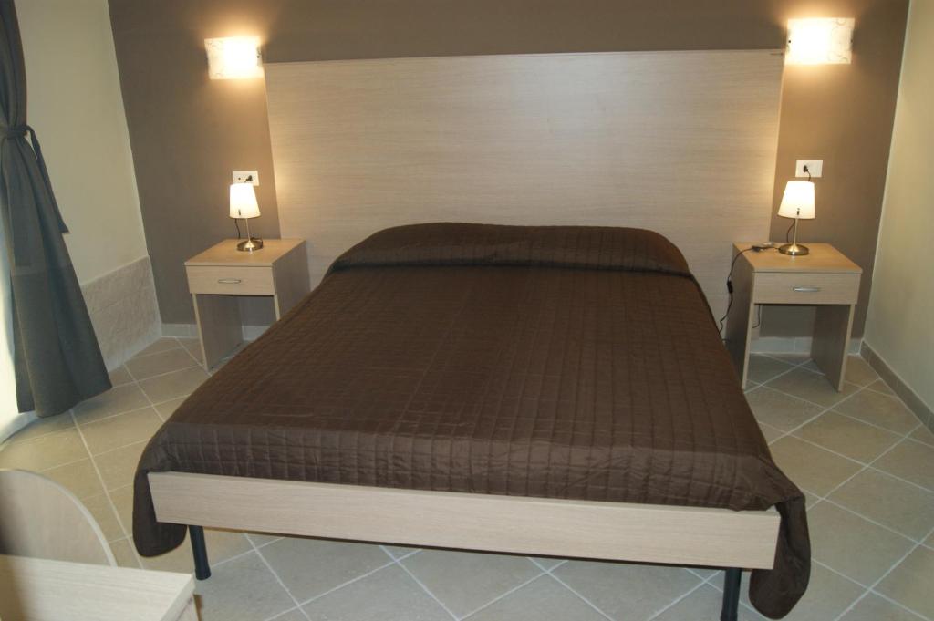 - une chambre avec un grand lit et 2 tables de chevet dans l'établissement Guest House Golfo Xifonio, à Augusta