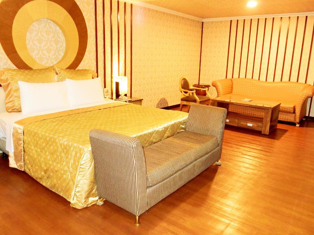 Habitación de hotel con cama y silla en Huang Xing Motel en Pingtung City