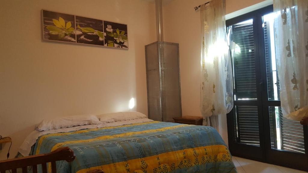um quarto com uma cama ao lado de uma janela e uma porta em Al Fontanone em Cecchina