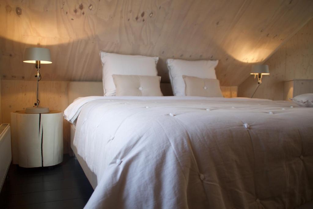 カンペンにあるHet Buitenhuisのベッドルーム(白い大型ベッド、ランプ2つ付)