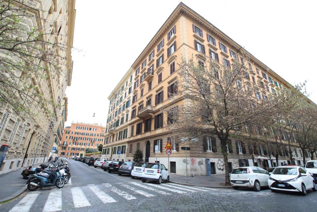 a city street with cars parked in front of a building at Matilde's Rooms in St. Peter in Rome