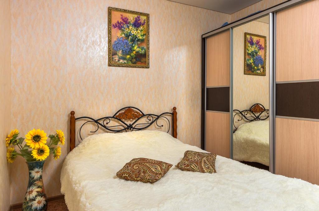 1 dormitorio con cama y espejo grande en Apartment 45 Str. Divizii 108 en Voronezh