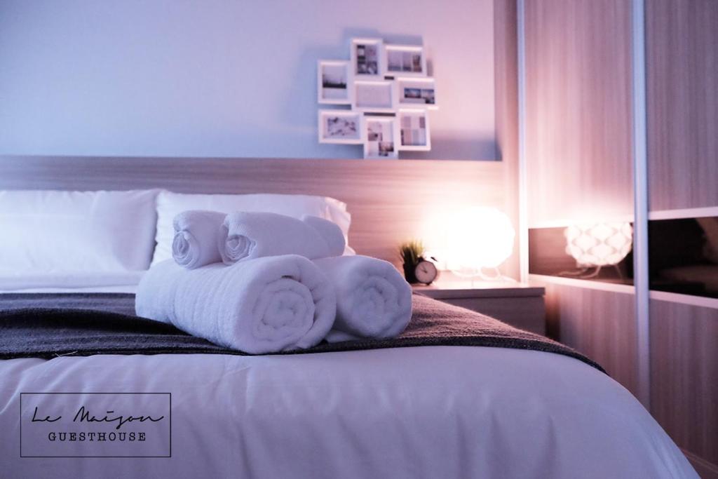 ein Schlafzimmer mit einem Bett mit Handtüchern darauf in der Unterkunft Le Maison GuestHouse Ipoh Majestic in Ipoh