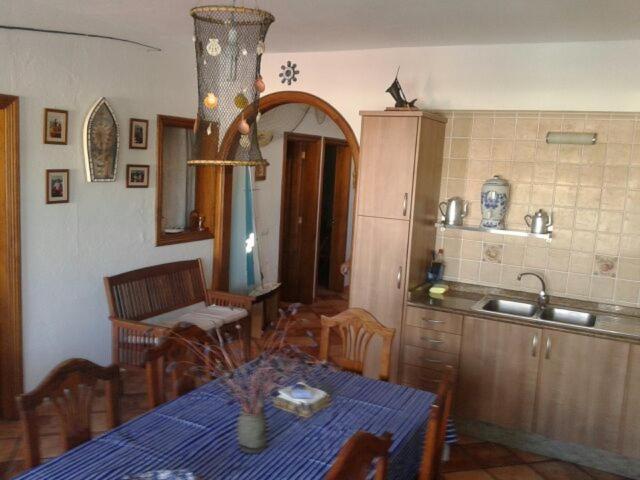 eine Küche und ein Esszimmer mit einem Tisch und einem Waschbecken in der Unterkunft El Pescador in Famara