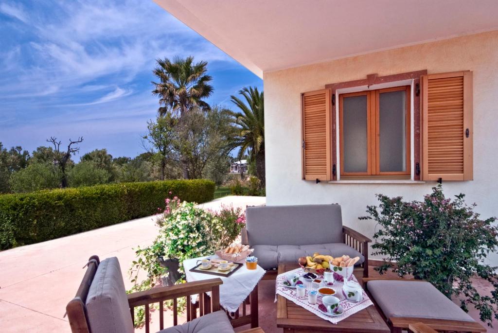 a patio with a couch and a table and a window at Agriturismo Sa Suerera in Olmedo