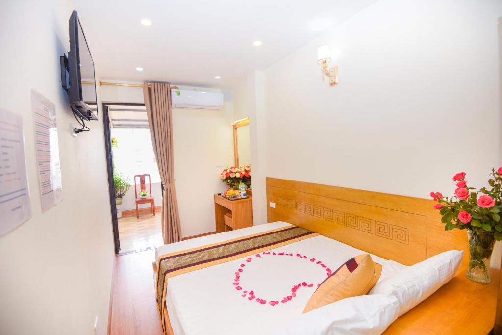 Una habitación con una cama con un collar rojo. en Old Town Palace Guest House, en Hanói