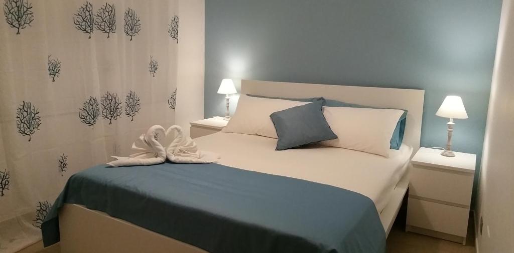 サンタ・テレーザ・ディ・リーヴァにあるLe sorelleのベッドルーム1室(青と白のシーツが備わるベッド1台付)