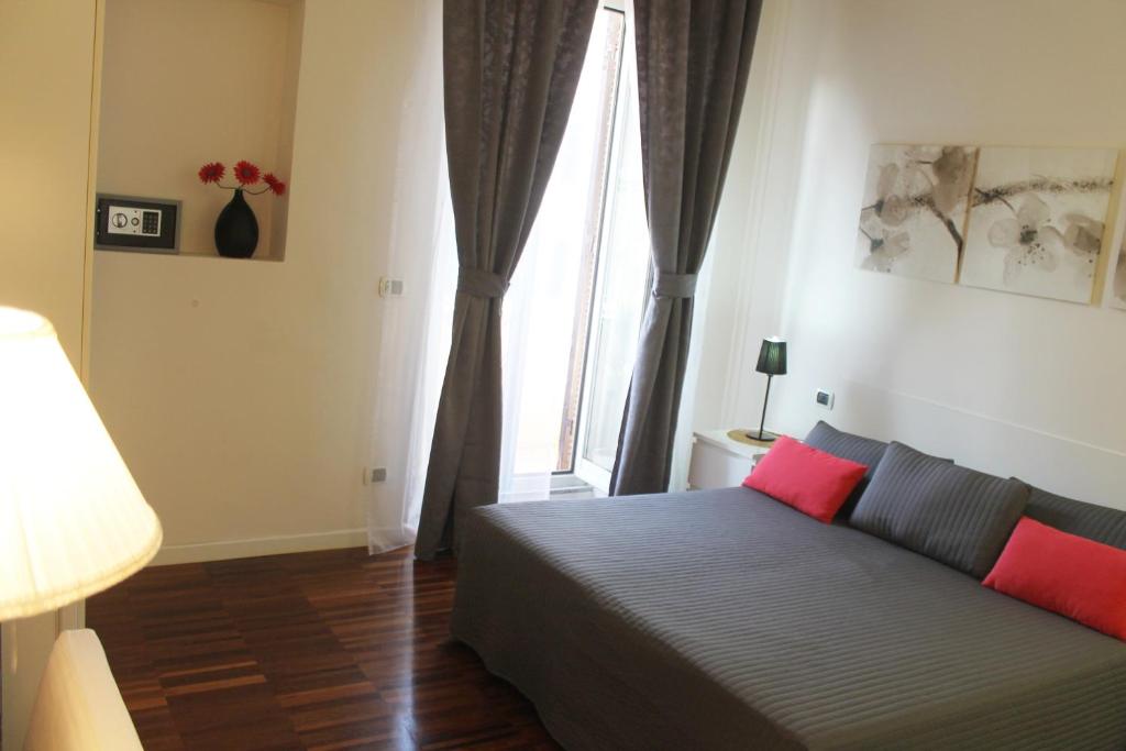 ローマにあるFornaci Guest Houseのベッドルーム1室(赤い枕のベッド1台、窓付)