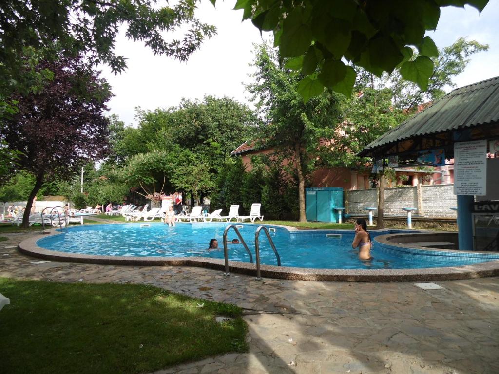 a swimming pool with people in the water at B&B Vila Raj in Vrnjačka Banja