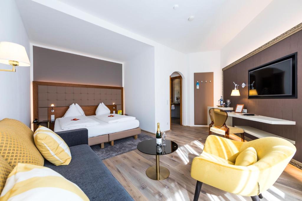 フェルデン・アム・ヴェルターゼーにあるHotel Goritschniggのベッドとリビングルームが備わるホテルルームです。