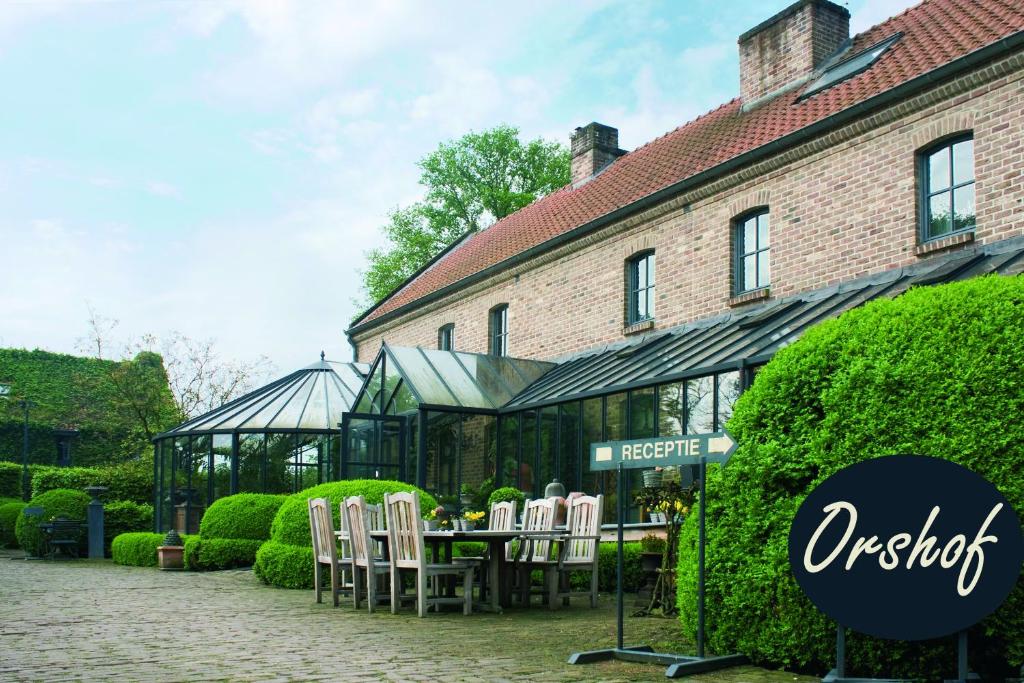 een tafel en stoelen voor een gebouw bij Orshof in Opglabbeek