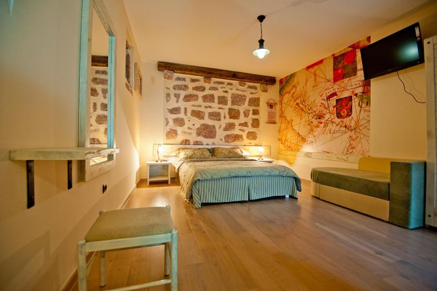um quarto com uma cama e uma televisão na parede em Medin di Lastua em Petrovac na Moru