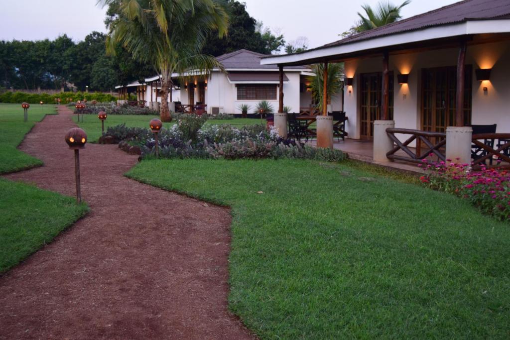a house with a walkway next to a yard at Ameg Lodge Kilimanjaro in Moshi