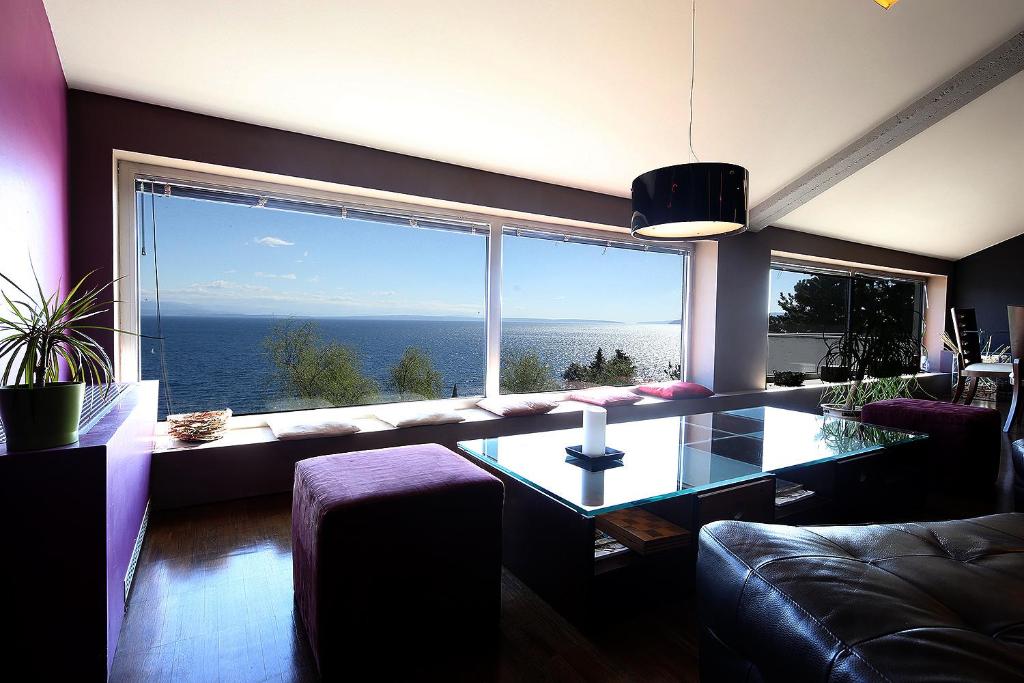 a living room with a table and a large window at Unique Apartment Opatija in Opatija