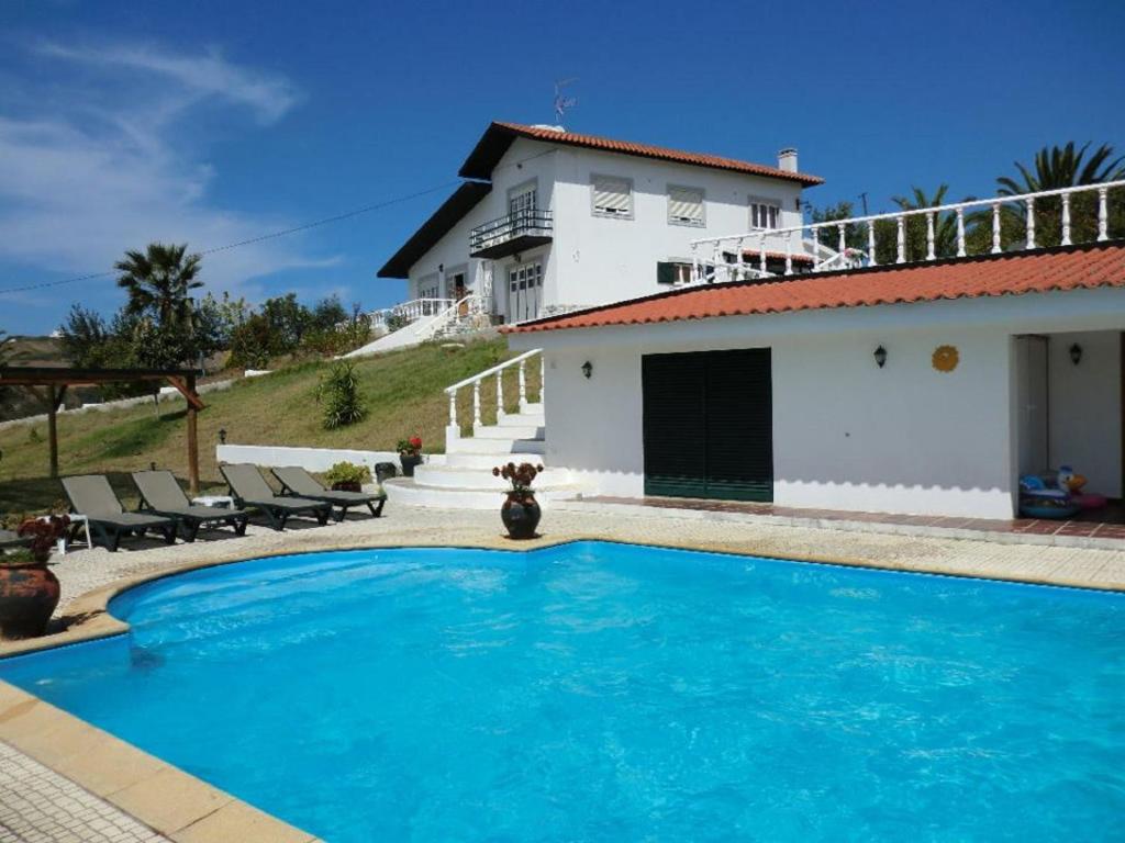 une maison avec une piscine en face d'une maison dans l'établissement Quinta Do Forno, à Vimeiro