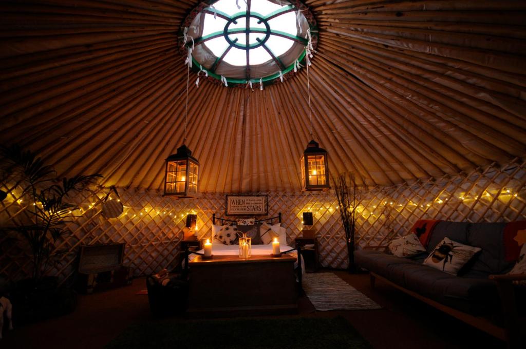 Una habitación con una yurta con velas y una ventana en Glamping on the Hill, en Mells