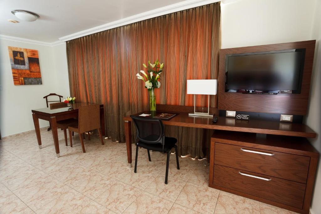 Una televisión o centro de entretenimiento en Hotel Coral Suites