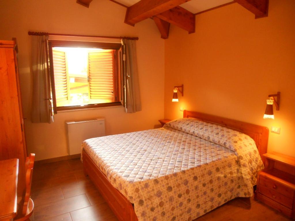 a bedroom with a bed and a window at La Locanda Del Lago Lucciola in Villalago