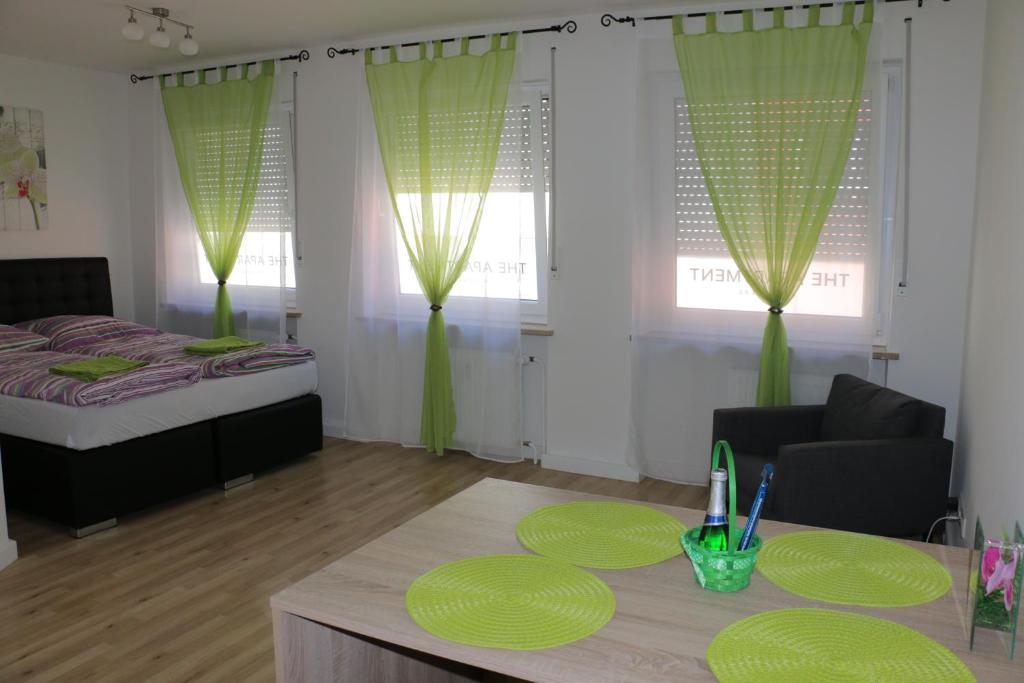 a bedroom with a bed and a table with green accents at City Center Apartments in Nürnberg