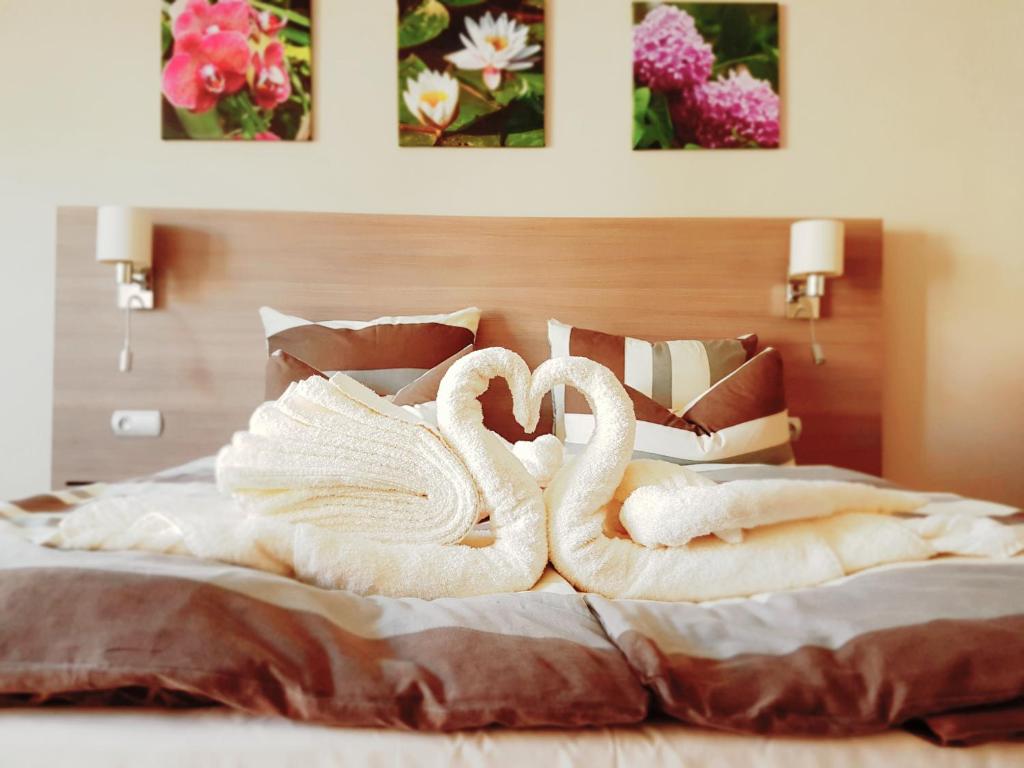 due cigni avvolti in asciugamani seduti su un letto di Willa Adonis a Świnoujście
