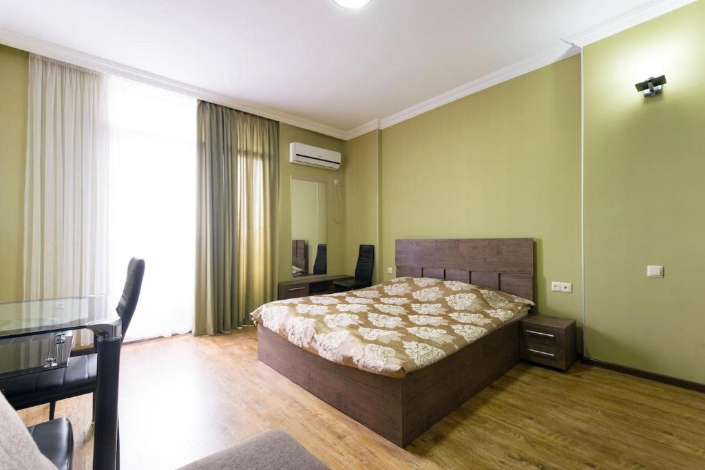 una camera con un letto in una stanza con pareti verdi di Apartment Orbi Rezidence a Batumi