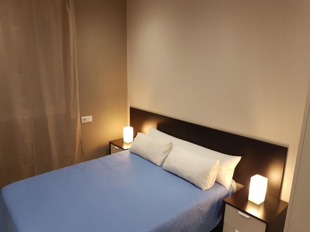 ウエルバにあるVivienda Reina Victoriaのベッドルーム1室(大型ベッド1台、2つの照明付)