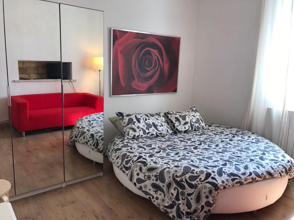 ローマにあるRome Suite' La Casa di Costantinoのベッドルーム1室(ベッド1台、赤いソファ付)