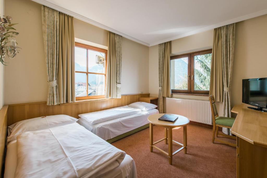 um quarto de hotel com duas camas e uma televisão em Gästehaus Reiter em Golling an der Salzach