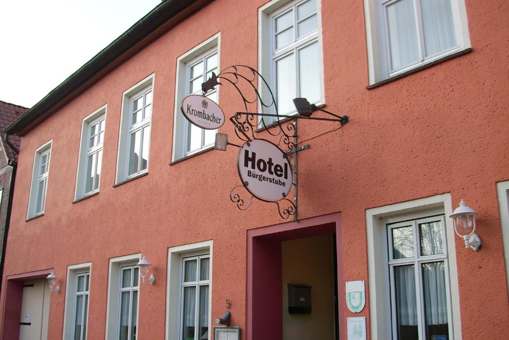 ein rotes Gebäude mit einem Hotelschild drauf in der Unterkunft Hotel Bürgerstube in Hitzacker