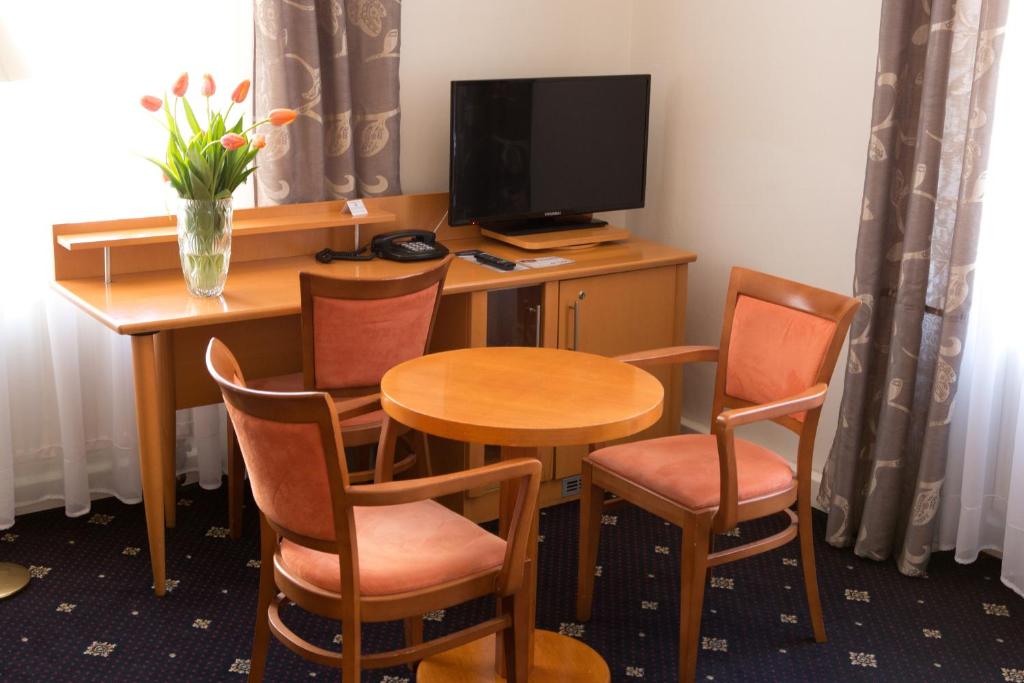 a room with a table and chairs and a television at Máchova in Prague