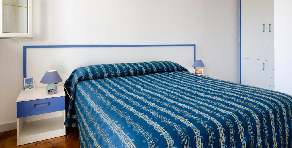 トッレ・ヴァードにあるAl Porticcioloのベッドルーム1室(青い掛け布団、ランプ2つ付)
