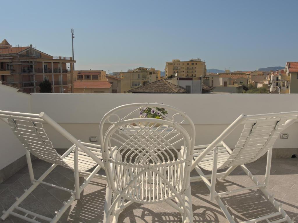 2 stoelen en een tafel op een balkon bij Holiday Alghero in Alghero