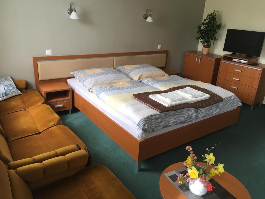 sypialnia z łóżkiem, krzesłem i stołem w obiekcie Apartmán Darmon w Pieszczanach