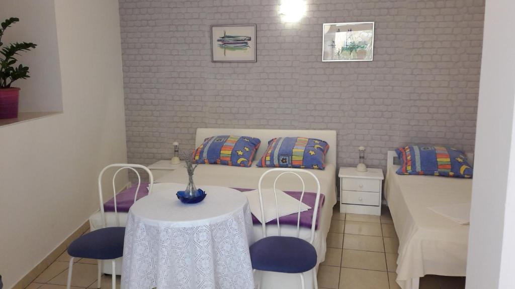 um pequeno quarto com uma mesa e duas camas em Guesthouse Ivan em Skradin