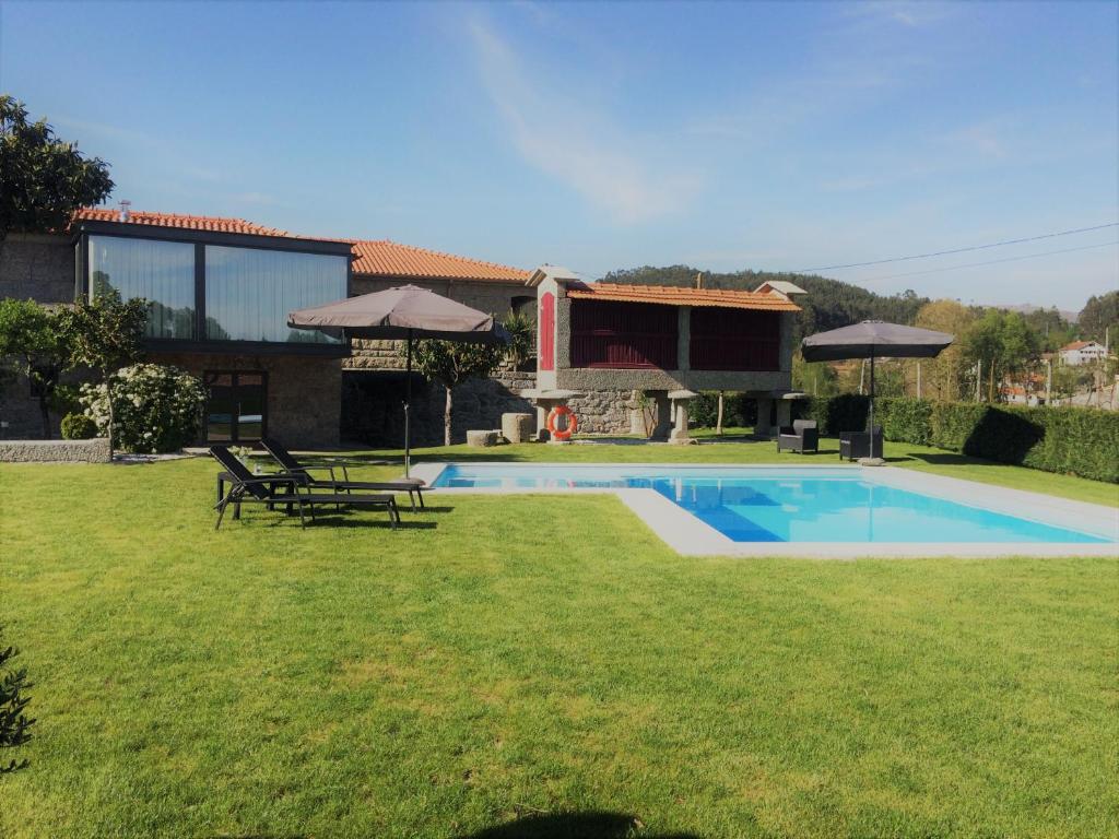 een tuin met een zwembad en een huis bij Casa do Sobreira in Vieira do Minho