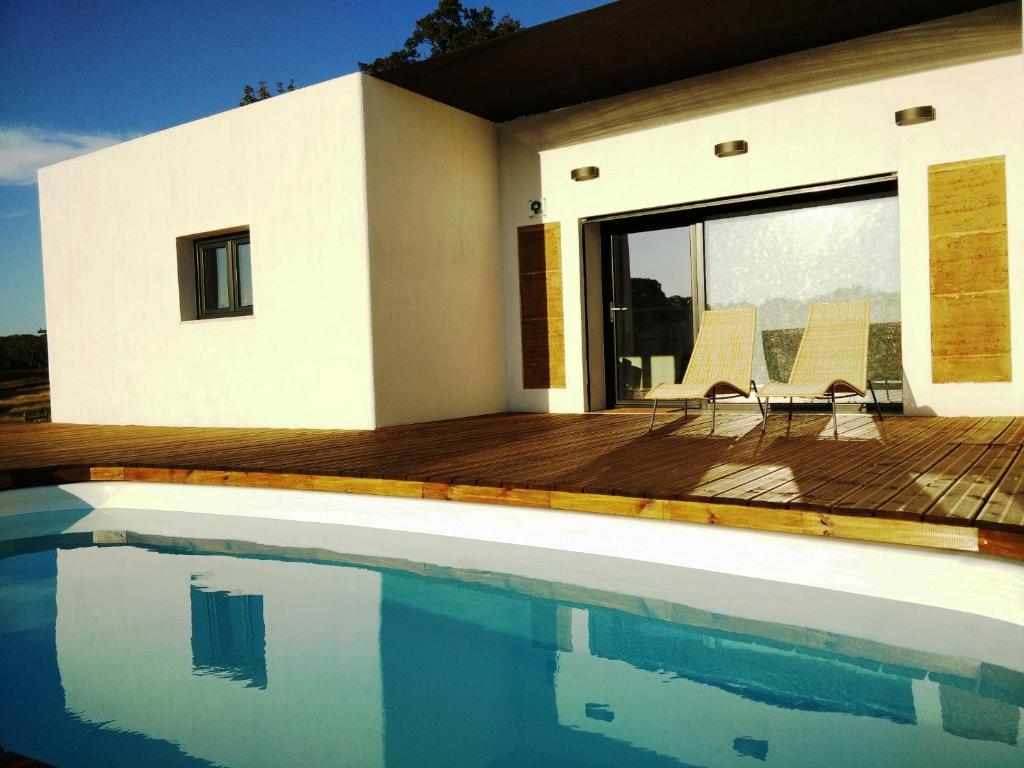 a house with a swimming pool in front of a house at Taipa 2 - Casas de Campo do Junqueirinho in Bicos
