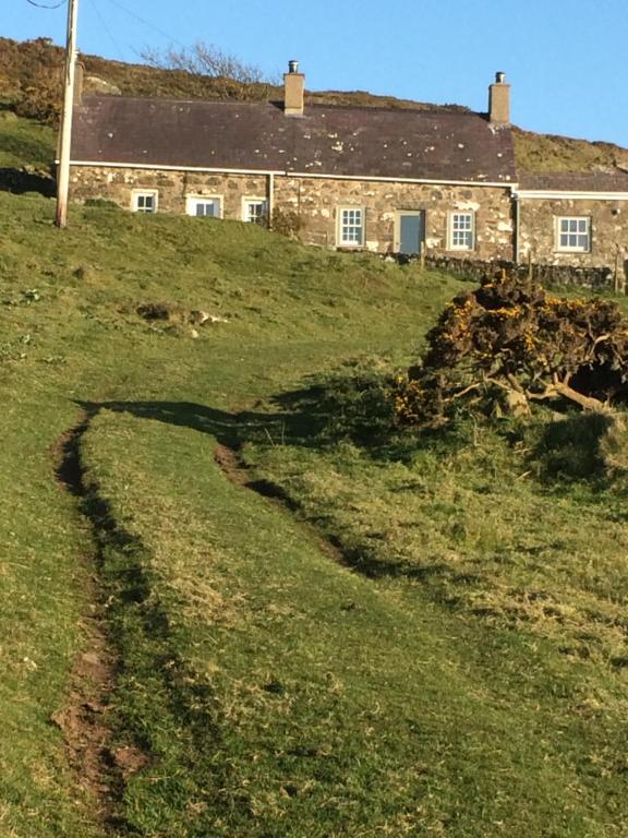 a house on a hill with a road leading to it at Rhiw 2 Bryn Tirion in Rhiw