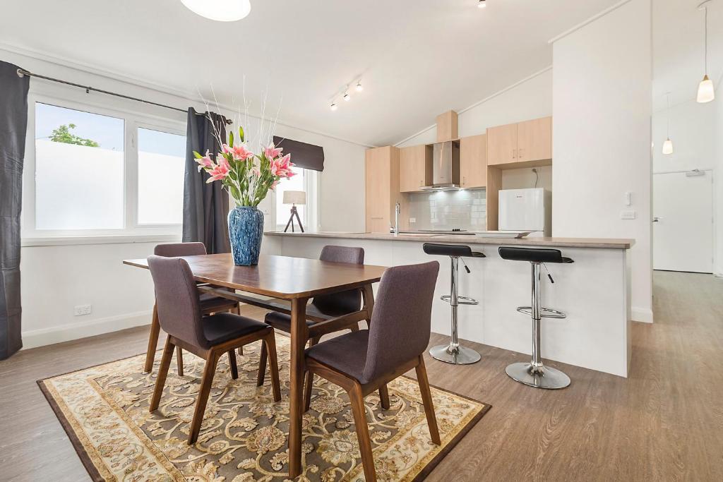 a kitchen and dining room with a wooden table and chairs at Blue Rosella on Piper in Kyneton